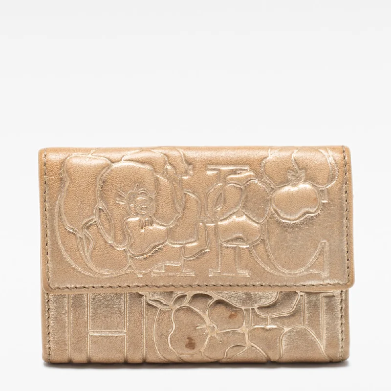 Women's money clip with a scalloped edge​Ch Carolina Herrera Gold Floral Embossed Leather Flap Compact Wallet